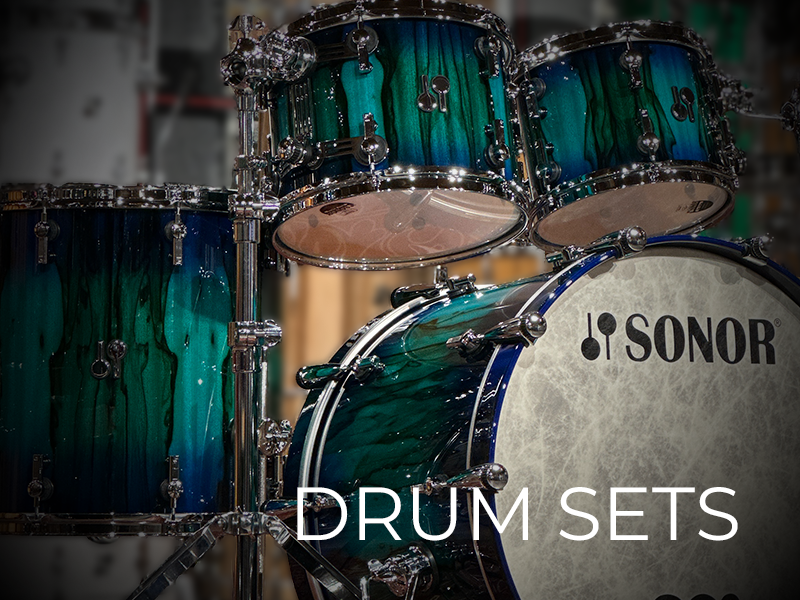 A teal and black Sonor drum set with two toms and a bass drum is shown with the text "DRUM SETS" overlaid.