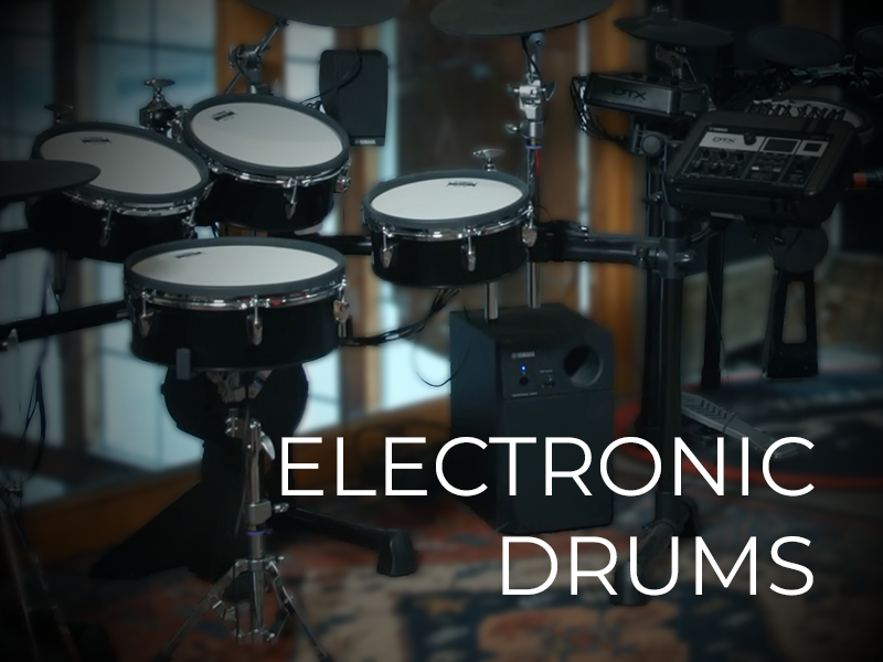A set of electronic drums with drum pads, cymbals, and control module in a room. Text on the image reads "ELECTRONIC DRUMS."